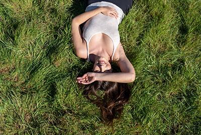 femme allongée dans l'herbe au soleil